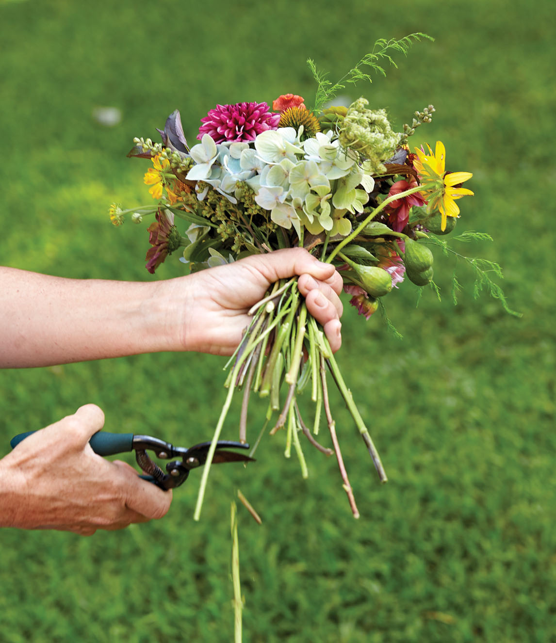 Kappi Naftel uses clippers to trim bouquet stems