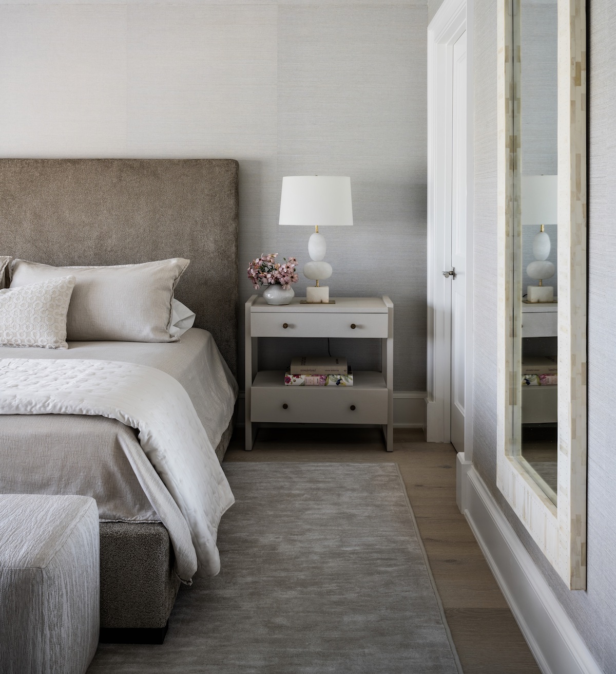 A neutral bedroom with a grey bedside table.