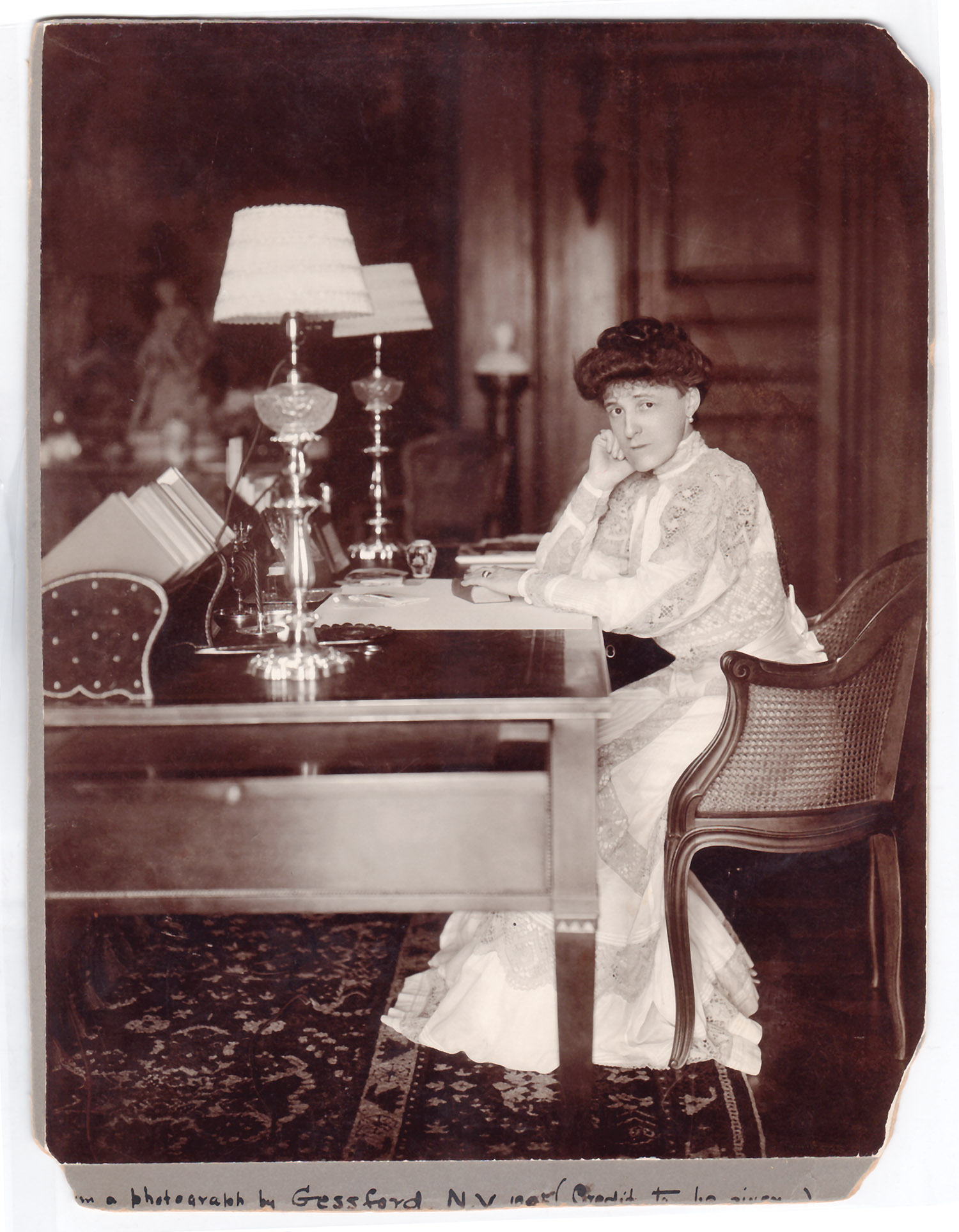Sepia toned picture of Edith Wharton at her desk.