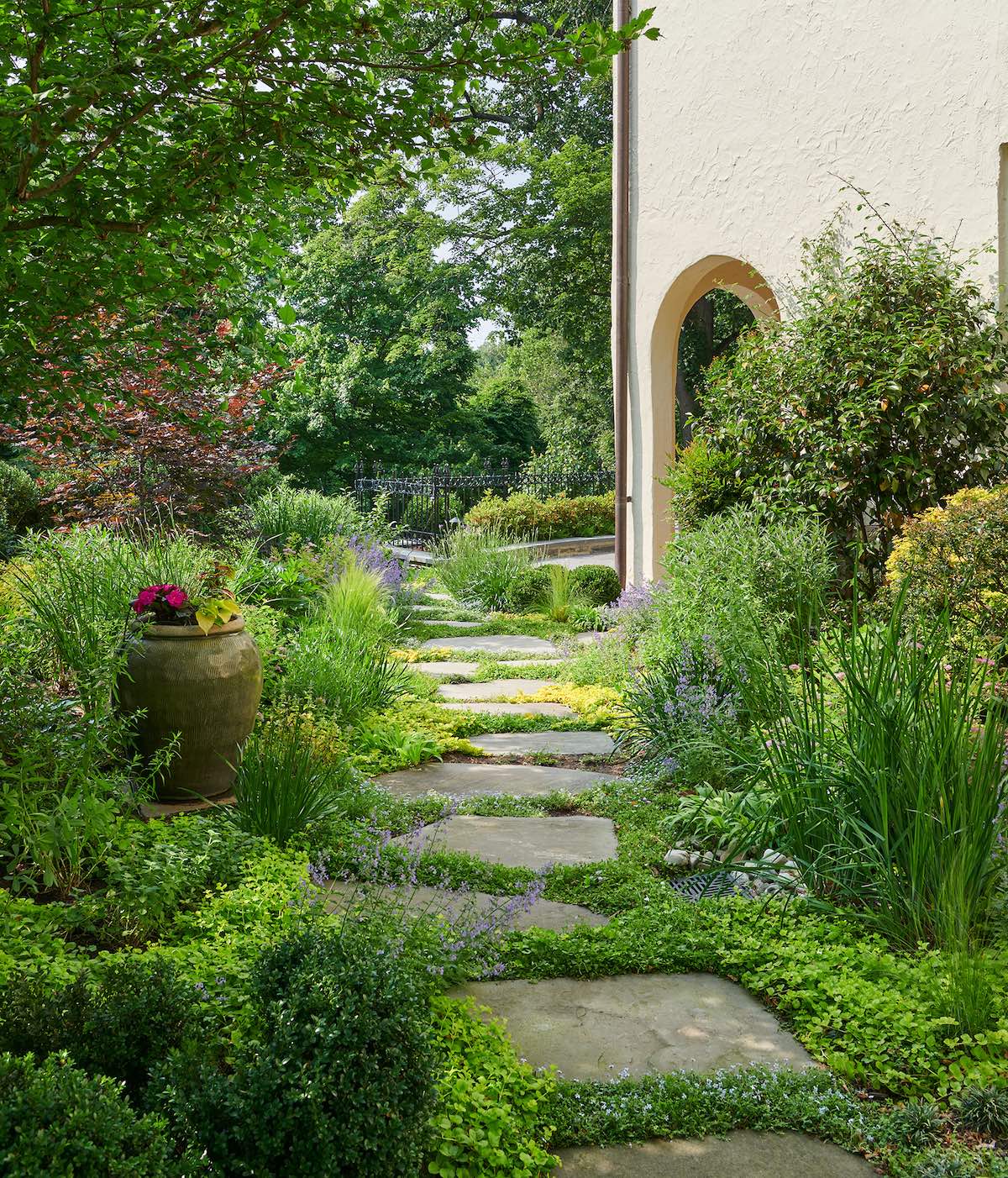 Charming stepping stone paths surrounded by lush plantings connect all areas in the landscape.