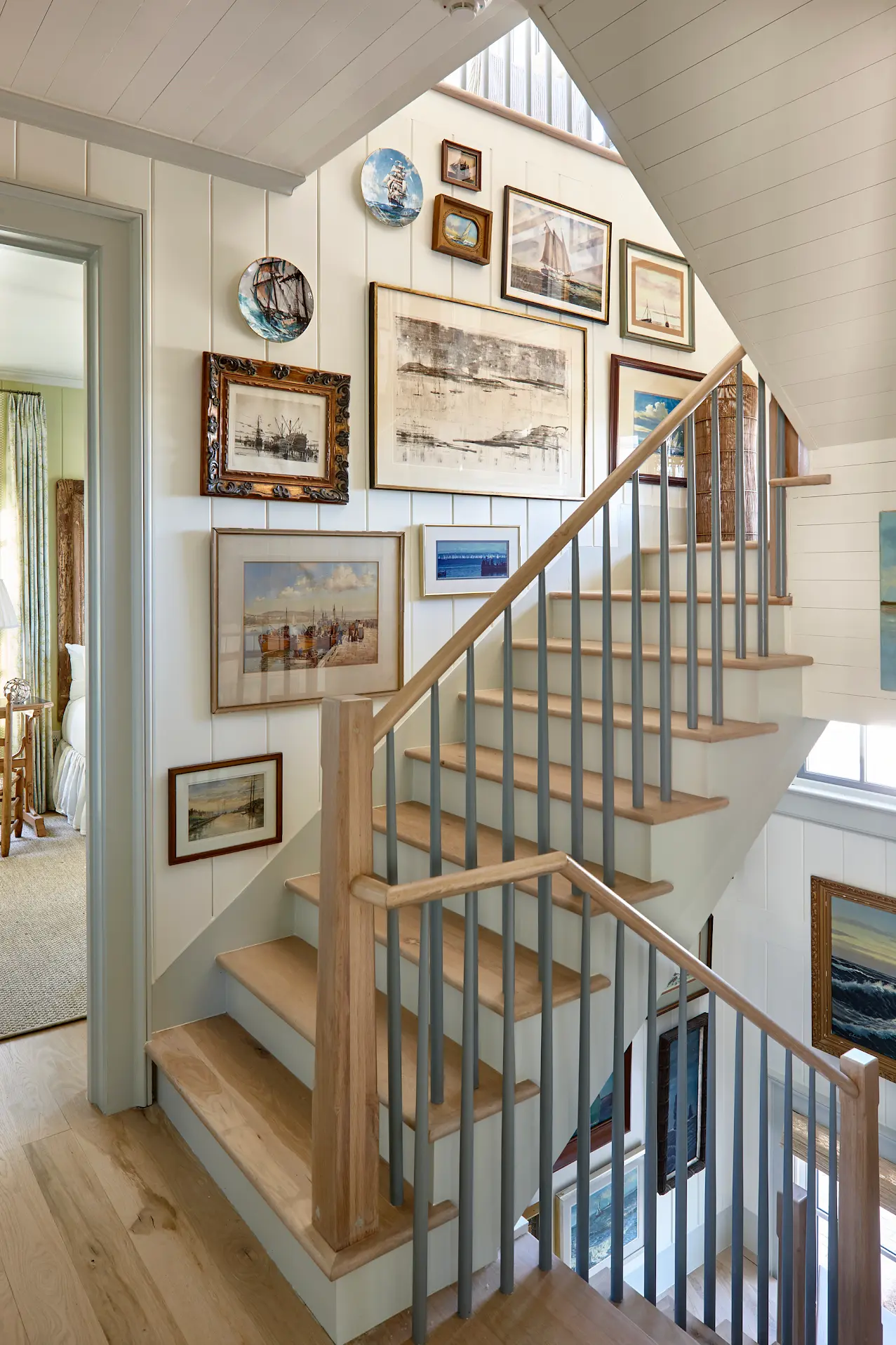 A coastal gallery wall runs up the stairs.