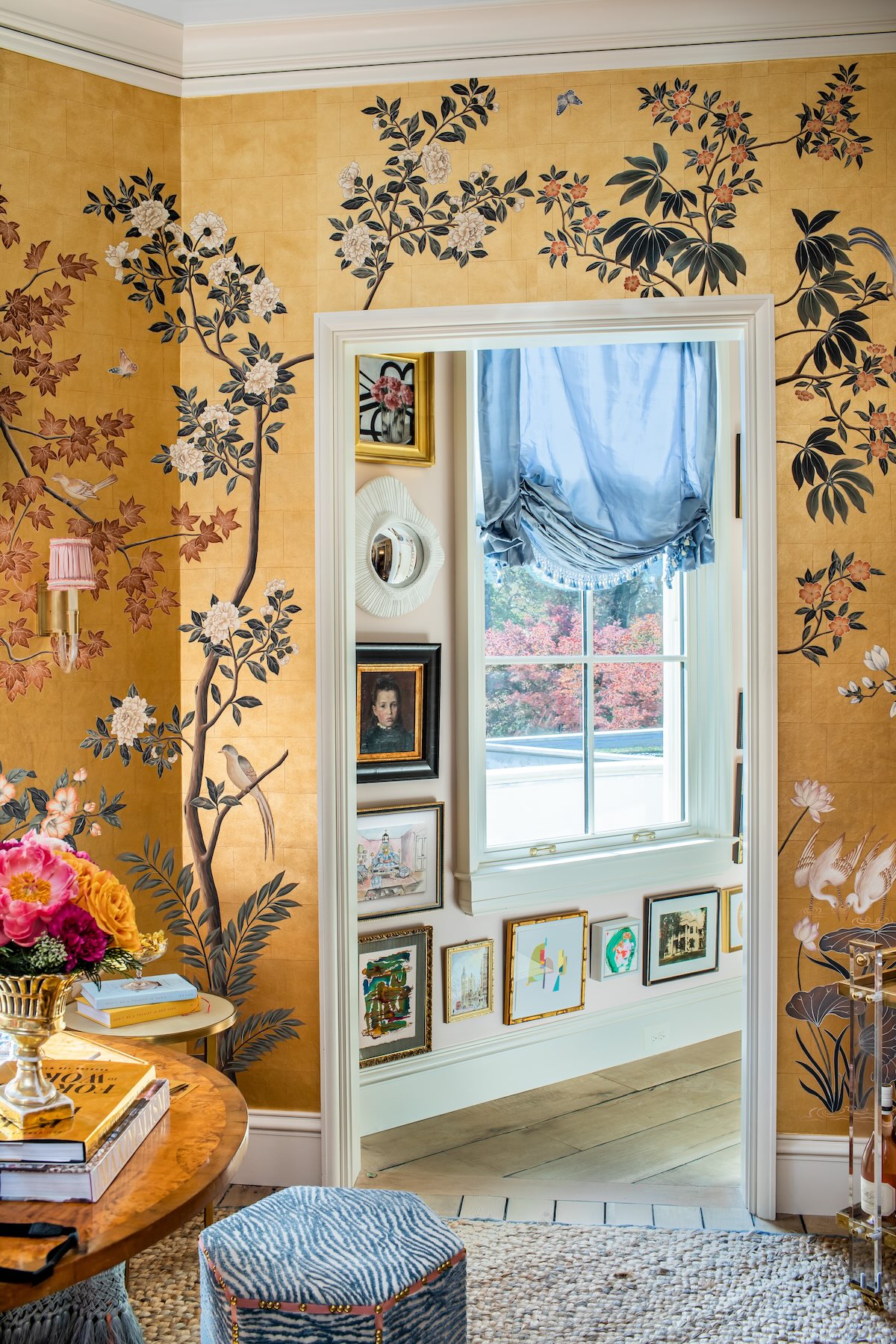 A gallery wall in a hallway next to a room wrapped in golden chinoiserie.