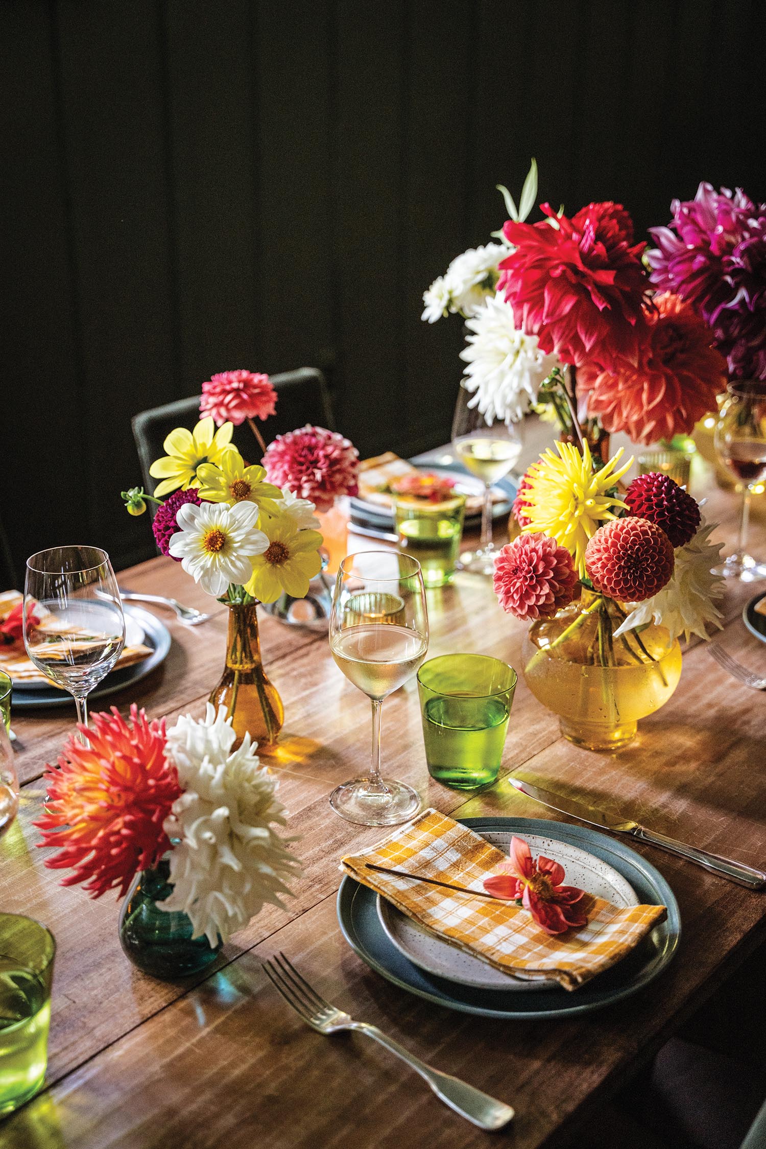 A table is set with rustic dinnerware and colorful dahlias.