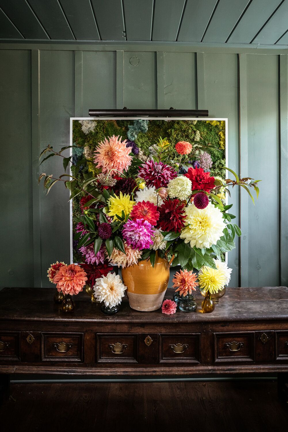 A large vase overflows with colorful dahlias.