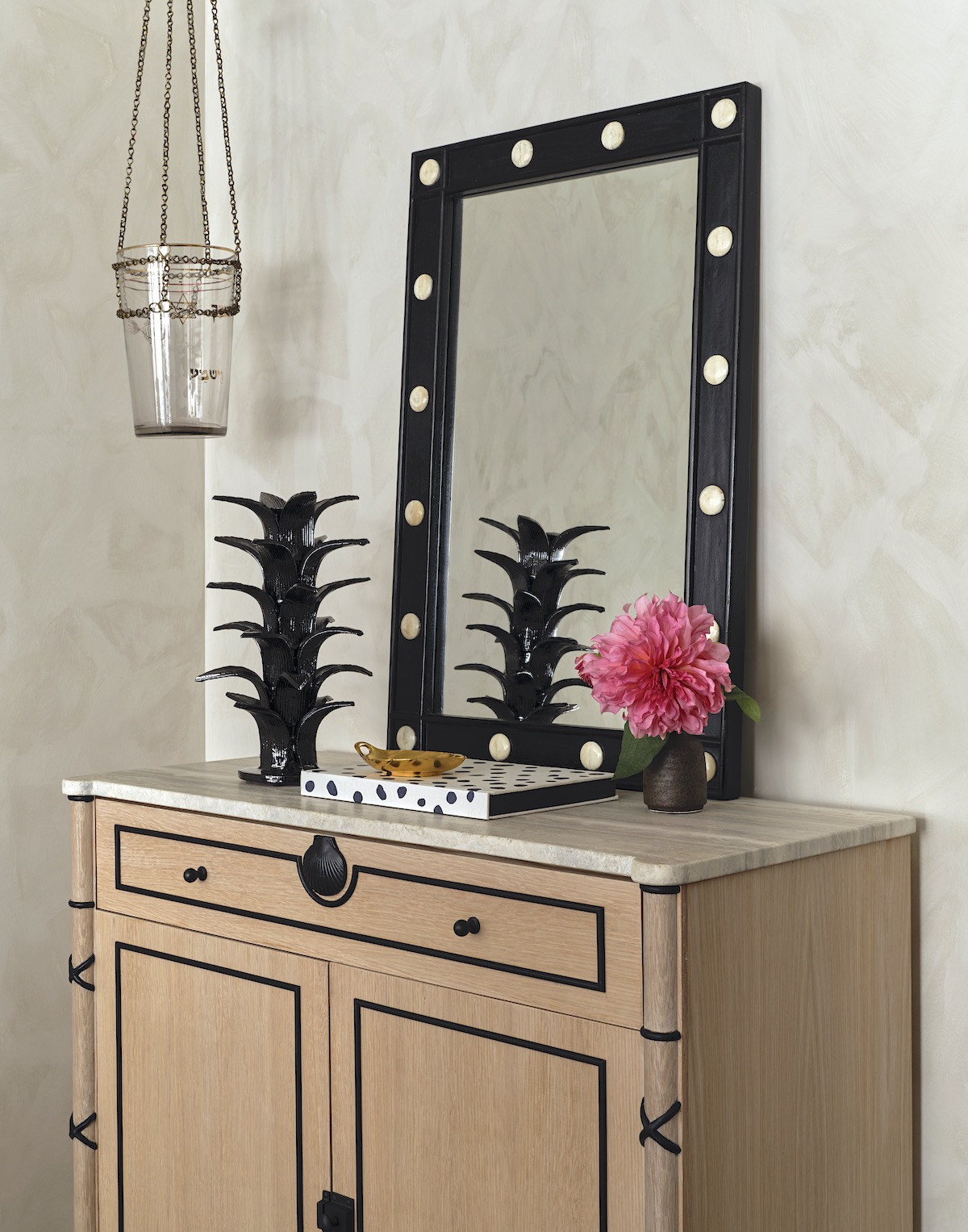 Light wood chest with black framed mirror on top.